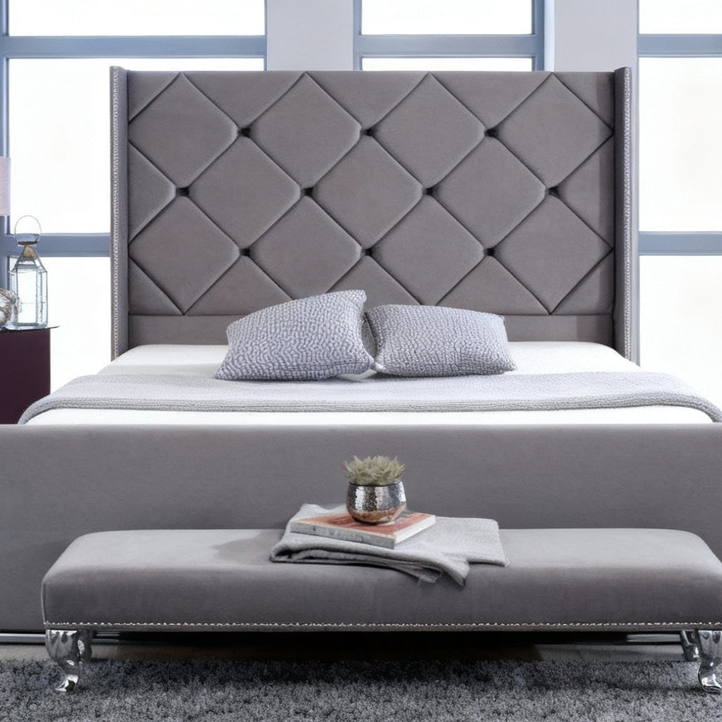 Gray upholstered bed with tufted headboard in a modern bedroom setting.