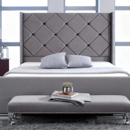 Gray upholstered bed with tufted headboard in a modern bedroom setting.