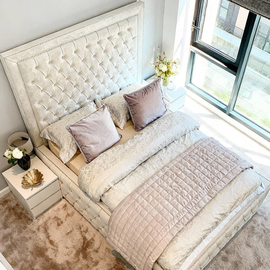 Neatly made bed with decorative pillows in a bright bedroom.